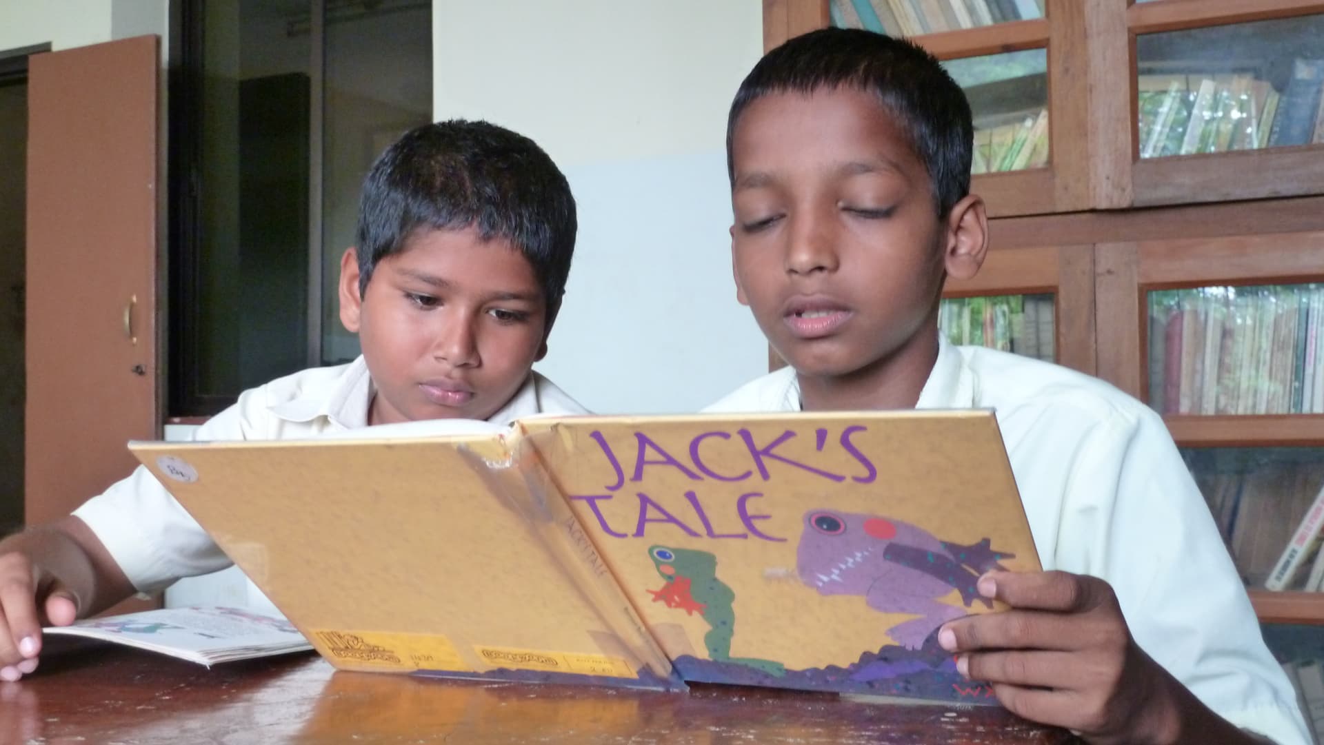 Two children reading a book together